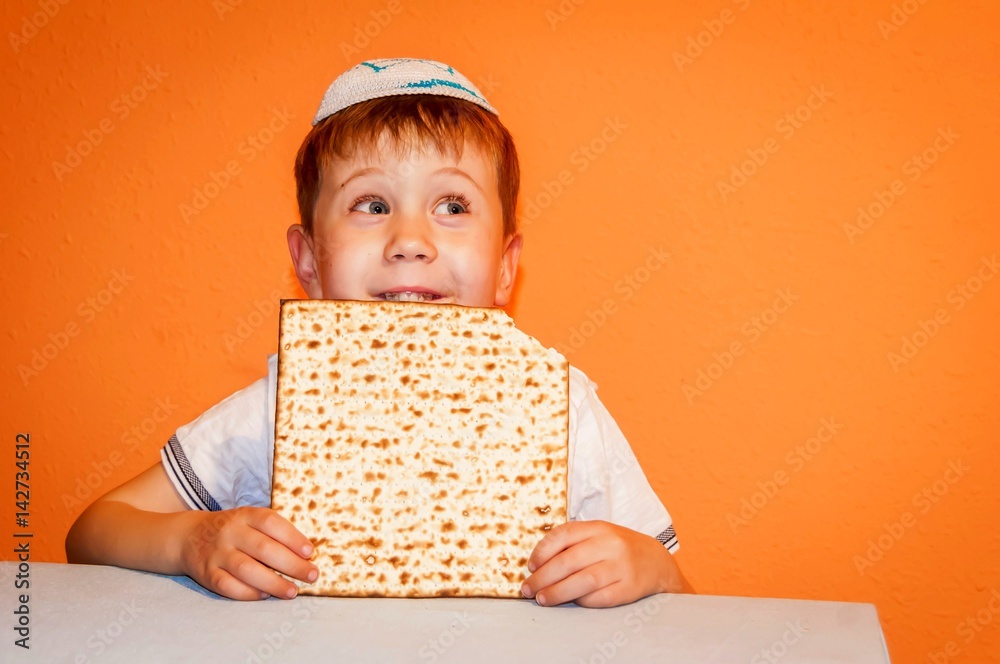 Happy little Jewish child with a kippah on his head looking forward for