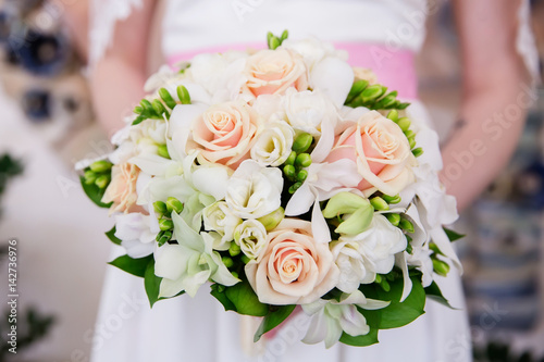 Beautiful wedding bouquet of flowers in bride   s hands