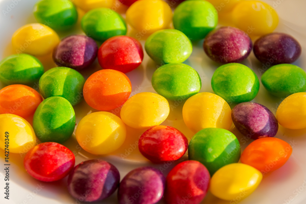 Closeup of the pile of colorful sweet bonbons. Scattered dragees of different colors. A colorful background. Closeup of the pile of colorful sweet bonbons. Scattered dragees of different colors. A colorful background.