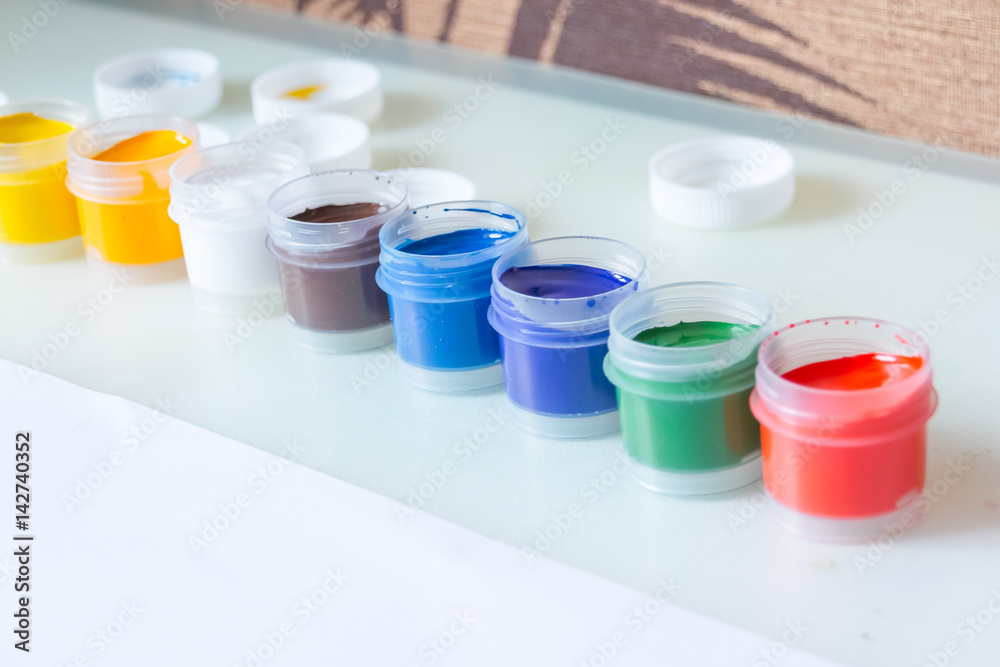 gouache. 8 gouache jars in a row. colorful gouache paint containers.rainbow gouache and piece of white paper gouache. 8 gouache jars in a row. colorful gouache paint containers.rainbow gouache and piece of white paper