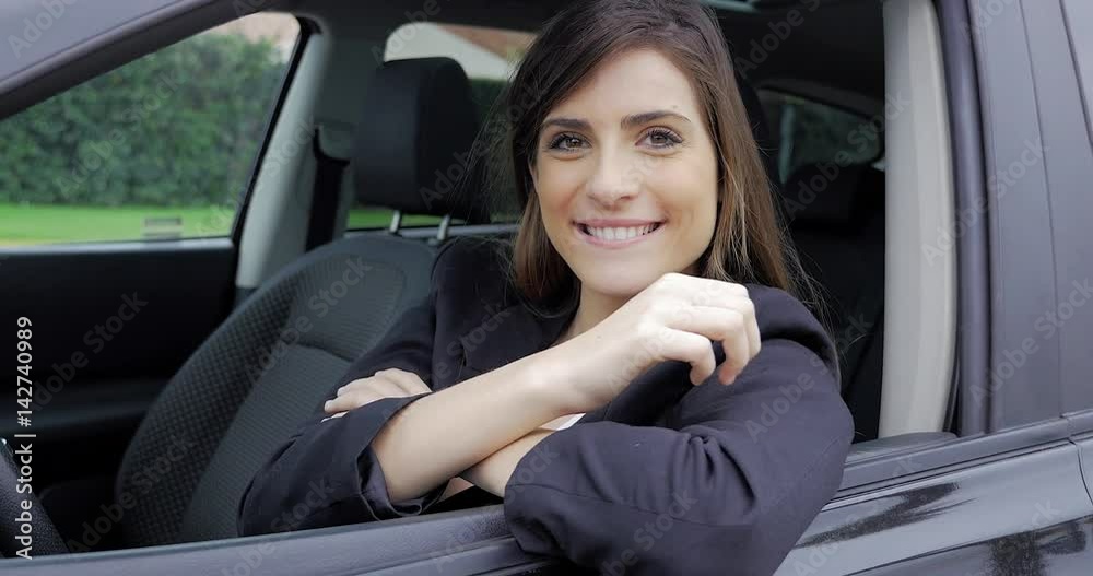 Cute young woman sitting in car looking camera ok sign Cute young woman sitting in car looking camera ok sign