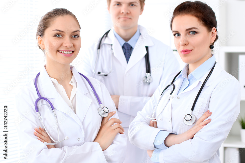 Happy female doctor with medical staff at the hospital. Successful team at health care concept Happy female doctor with medical staff at the hospital. Successful team at health care concept