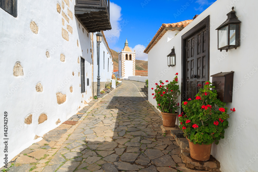 Narrow street in Betancuria village with Santa Maria church tower in background, Fuerteventura, Canary Islands, Spain