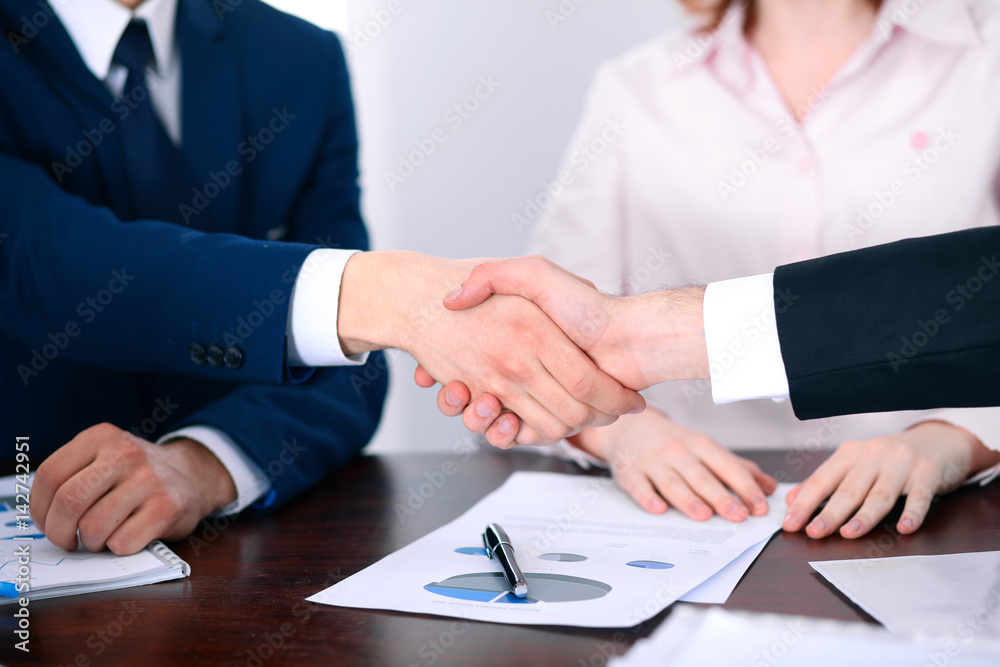 Business people shaking hands finishing up a meeting Business people shaking hands finishing up a meeting
