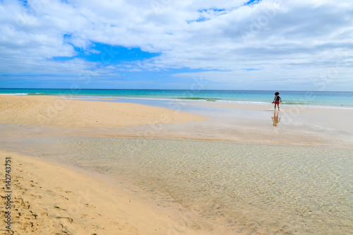 Woman standing on Morro Jable beach on Jandia peninsula, Fuerteventura, Canary Islands, Spain
