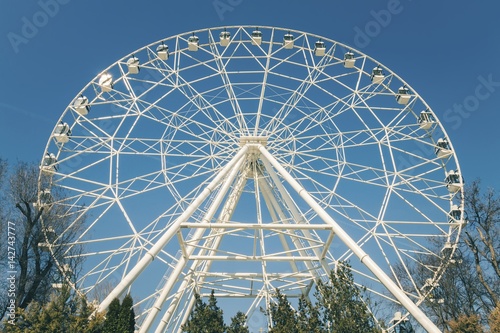 White ferris wheel against a blue sky. Stock image.