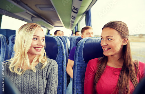 happy young women talking in travel bus © Syda Productions