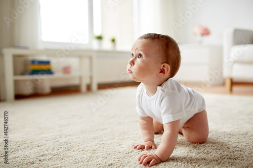 little baby in diaper crawling on floor at home