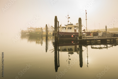 Fishing boats awaiting delayed departure in harbour due to heavy fog