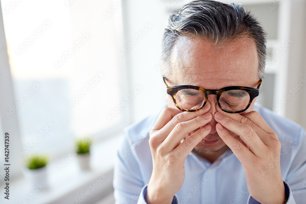 businessman in glasses rubbing eyes at office businessman in glasses rubbing eyes at office