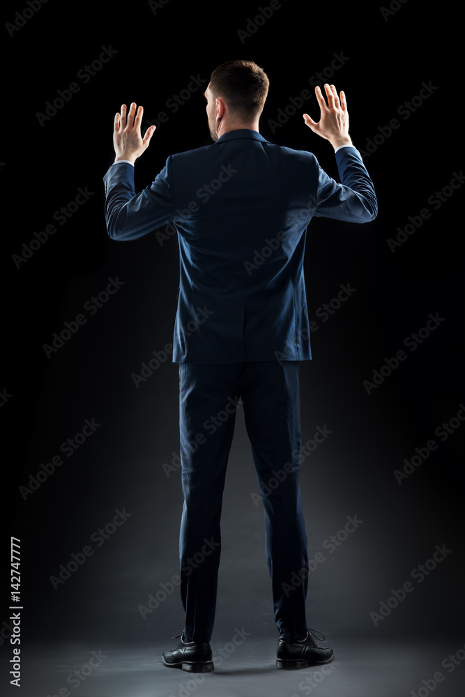businessman in suit touching something invisible businessman in suit touching something invisible