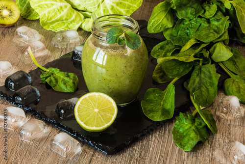 Detox diet. Green smoothie with fruits and vegetables on wooden dark background