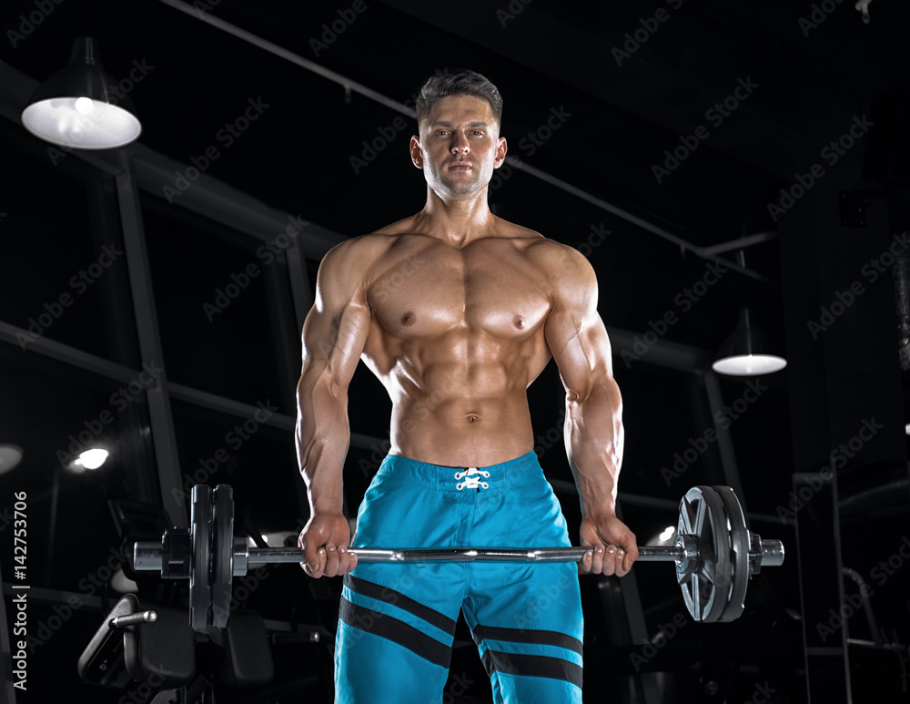 Young handsome guy doing exercises in the gym Young handsome guy doing exercises in the gym