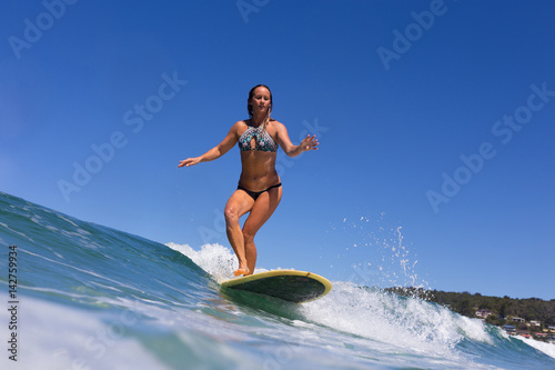 Surfer Cross Stepping and Balancing on a Longboard