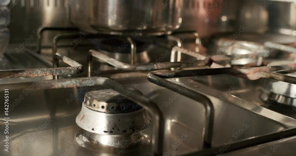 Close up hand lighting gas stove in kitchen