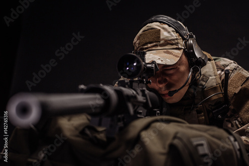 military contracto with his sniper rifle at night. war, army, weapon, technology and people concept