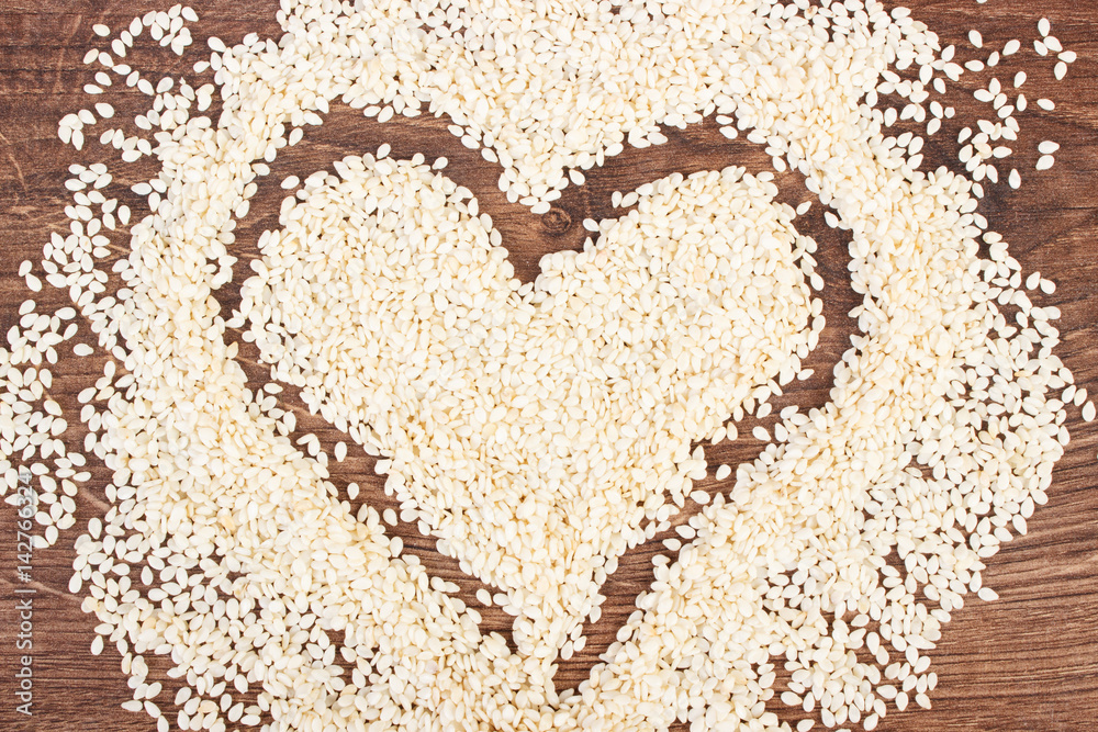Heart of sesame seeds on board, healthy nutrition concept and sumbol of love