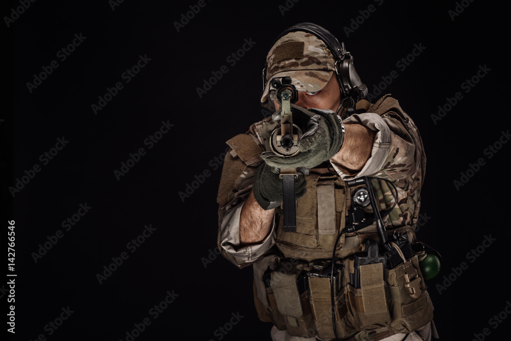 Portrait soldier or private military contractor holding sniper rifle. war, army, weapon, technology and people concept. Image on a black background. Portrait soldier or private military contractor holding sniper rifle. war, army, weapon, technology and people concept. Image on a black background.