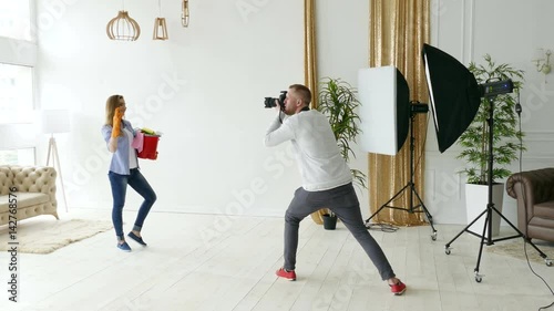 
Photographer works in studio with model like housewife. Backstage. 
