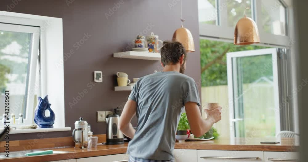 Woman dancing in kitchen wearing pajamas in the morning listening to music Woman dancing in kitchen wearing pajamas in the morning listening to music