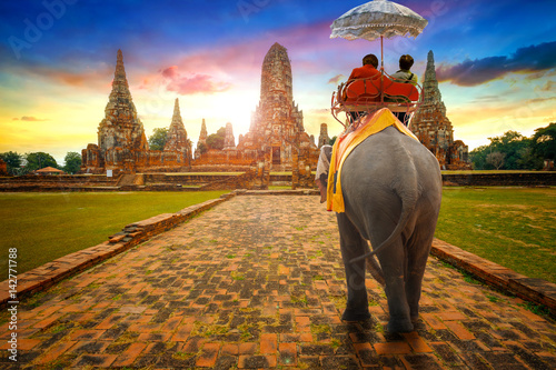 Tourists Ride an Elephant at Wat Chaiwatthanaram temple in Ayuthaya Historical Park, a UNESCO world heritage site in Thailand