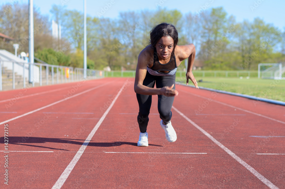 Woman doing sprint training on a sports track Woman doing sprint training on a sports track