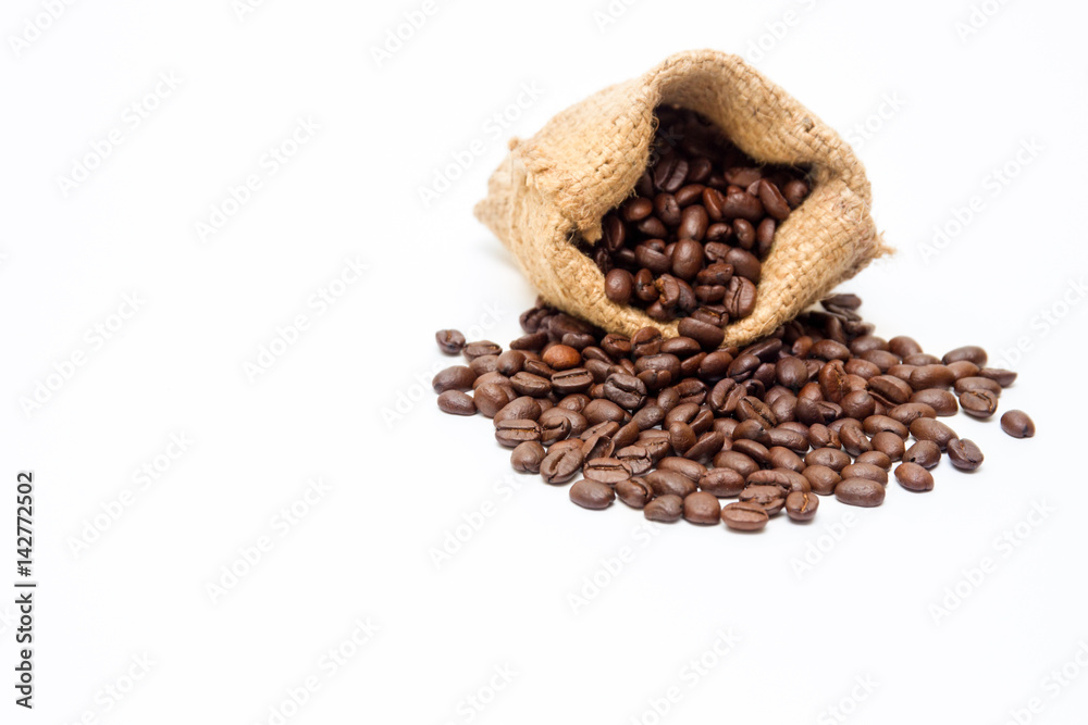 Organic coffee beans and wooden coffee dipper on white background close up isolated.