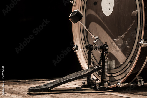 percussion instrument, bass drum with pedal on wooden boards with a black background
