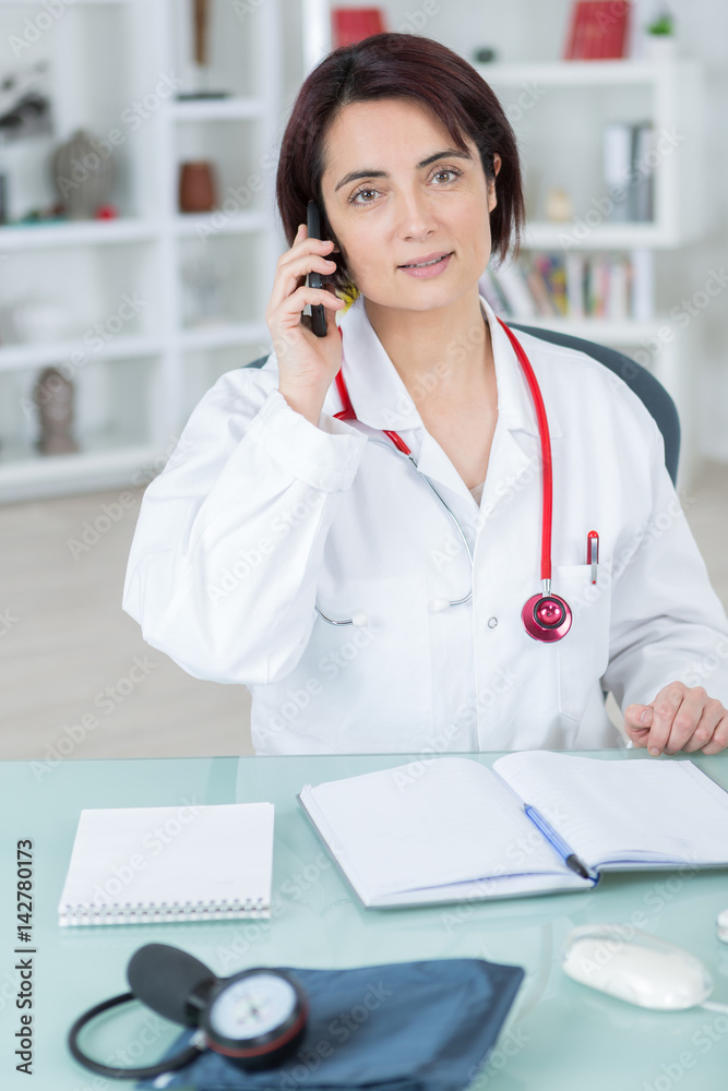 female doctor talking on phone in her office female doctor talking on phone in her office