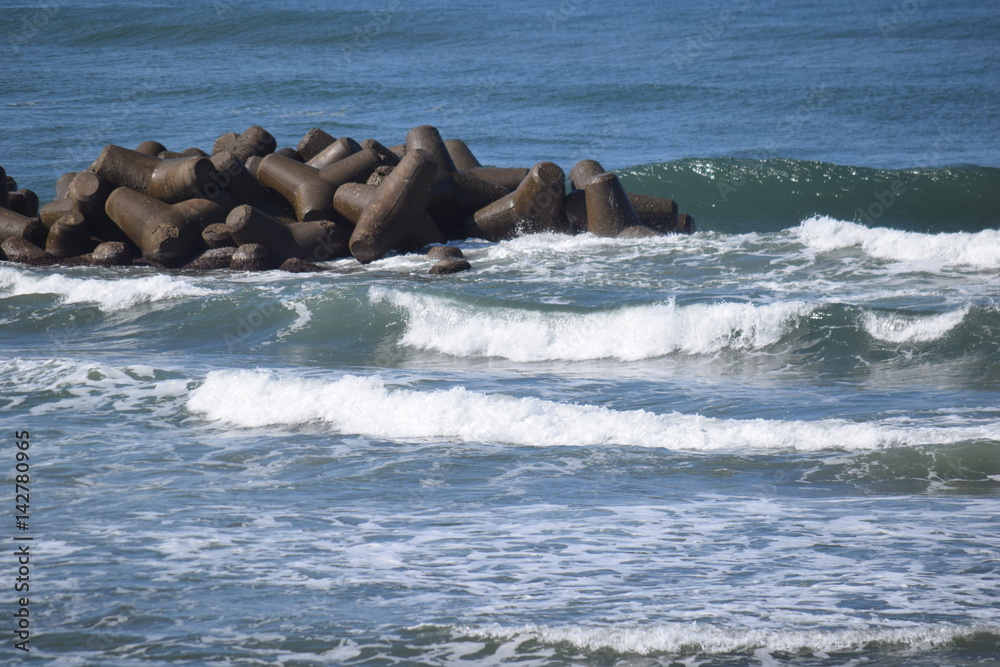 Fototapeta premium 消波ブロック ／ 海岸や河川などの護岸を目的に設置するコンクリートブロックです。海岸沿いに多数のブロックをかみ合わせて並べることで、波のエネルギーを減衰・消散させる事が可能です。また、このブロックにより、水中に複雑で多様な生物生息空間を提供し、円滑な生態系が形成され豊かな水域環境を創り出しています。