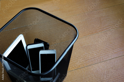 Smartphones in trash bin with copy space