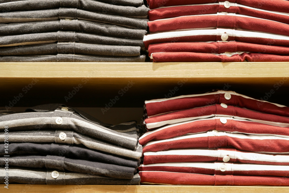 Folded polo shirts in a wood shelves