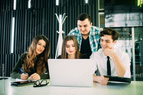 Young freelancer over laptop at meeting in modern office photo