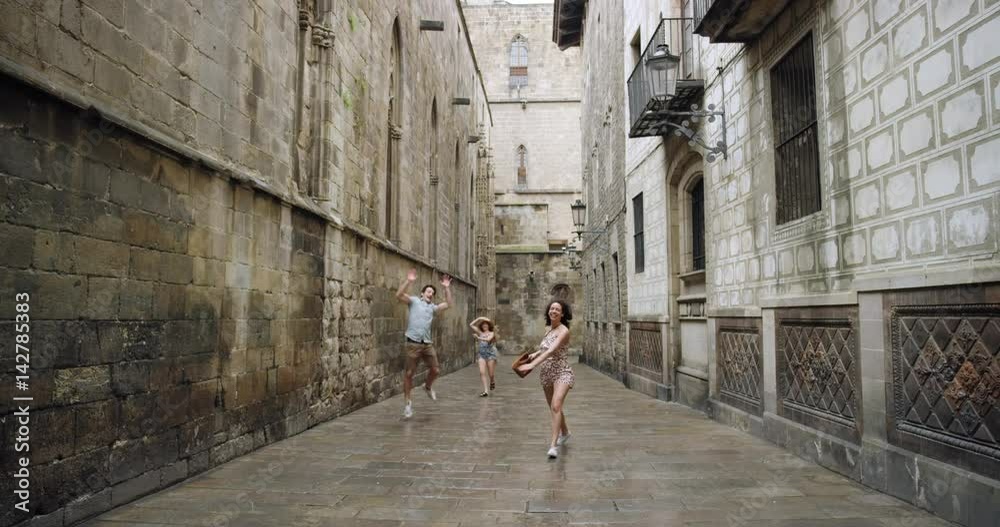 Diverse group of friends dancing freestyle in European City summer dress in rainy weather celebrating travel adventure Diverse group of friends dancing freestyle in European City summer dress in rainy weather celebrating travel adventure