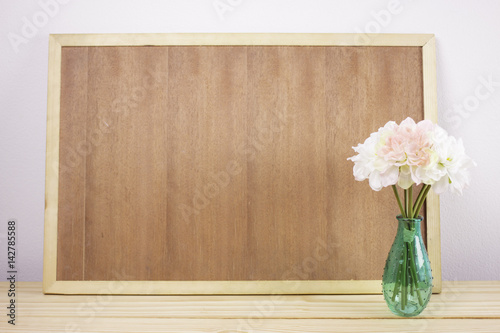 wooden board frame empty copy space and flowers in vase with vintage filter. focus on a vase. photo