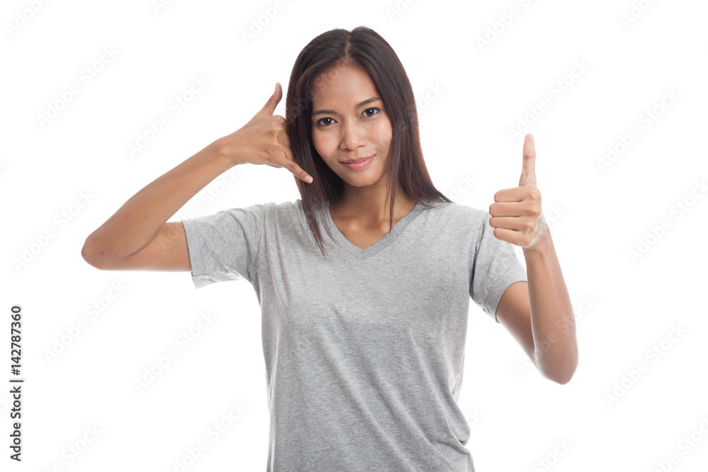 Young Asian woman thumbs up show with phone gesture. Young Asian woman thumbs up show with phone gesture.