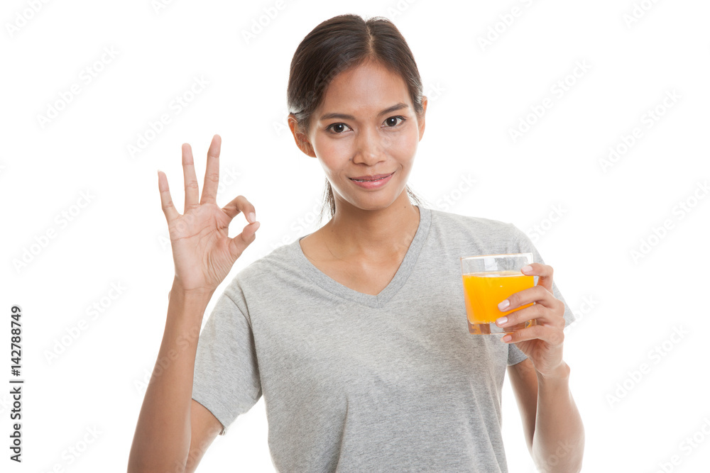 Young Asian woman drink orange juice show OK sign. Young Asian woman drink orange juice show OK sign.