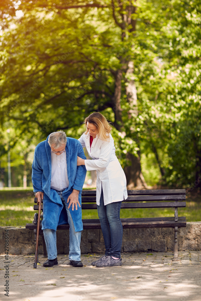 Nurse helping elderly disabled man . Nurse helping elderly disabled man .