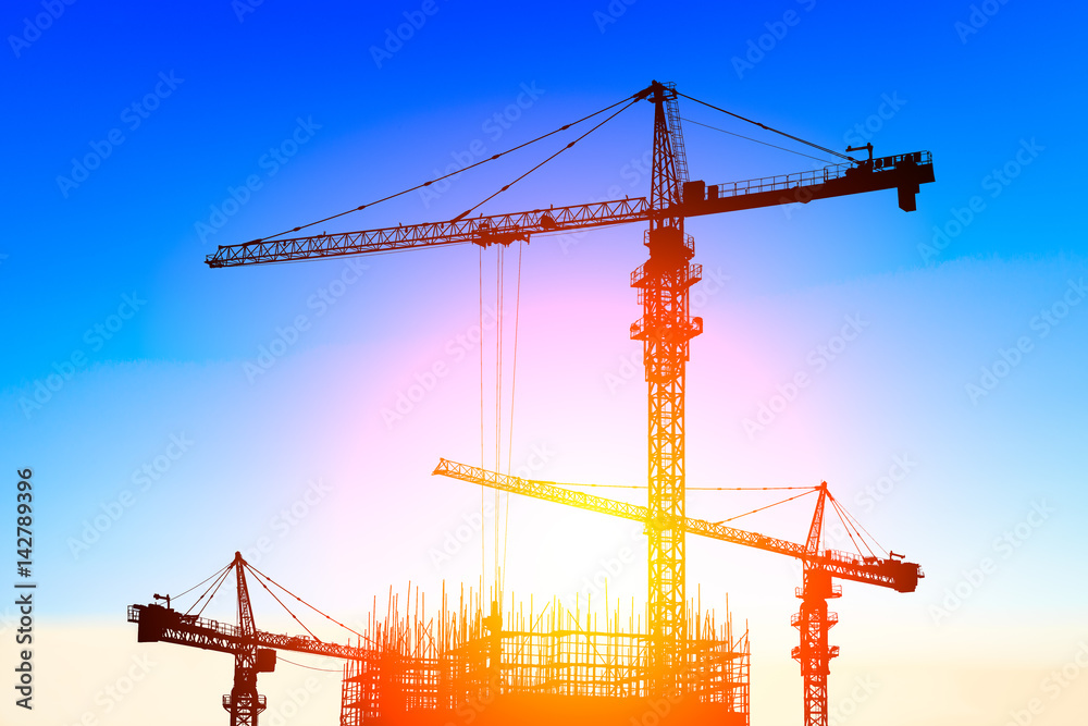 Crane and building construction site at sunset Crane and building construction site at sunset