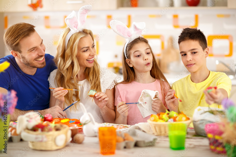 Happy family painting Easter eggs together Happy family painting Easter eggs together