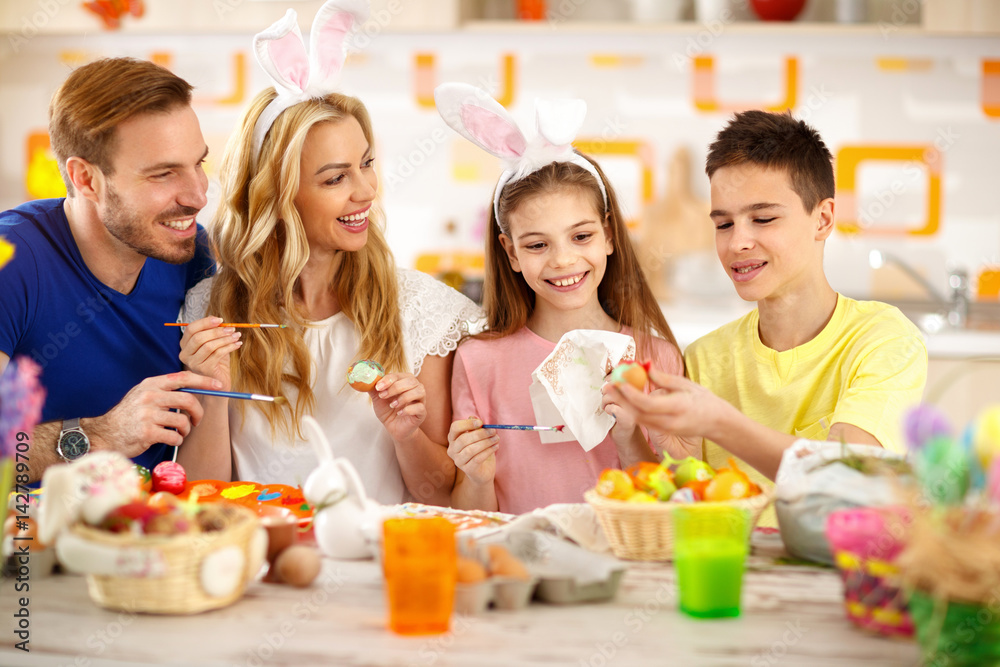 Happy family painting Easter eggs together Happy family painting Easter eggs together