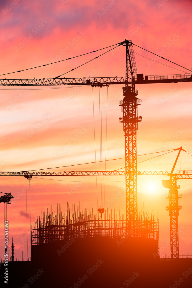 Crane and building construction site at sunset