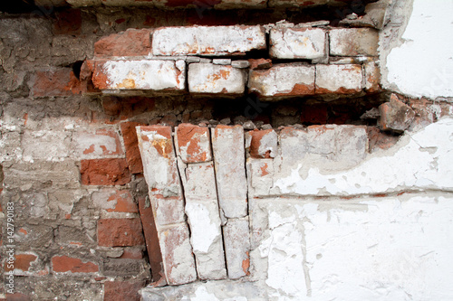 Vintage background texture of old brick masonry on ancient cement with cracks with traces of old paint. photo