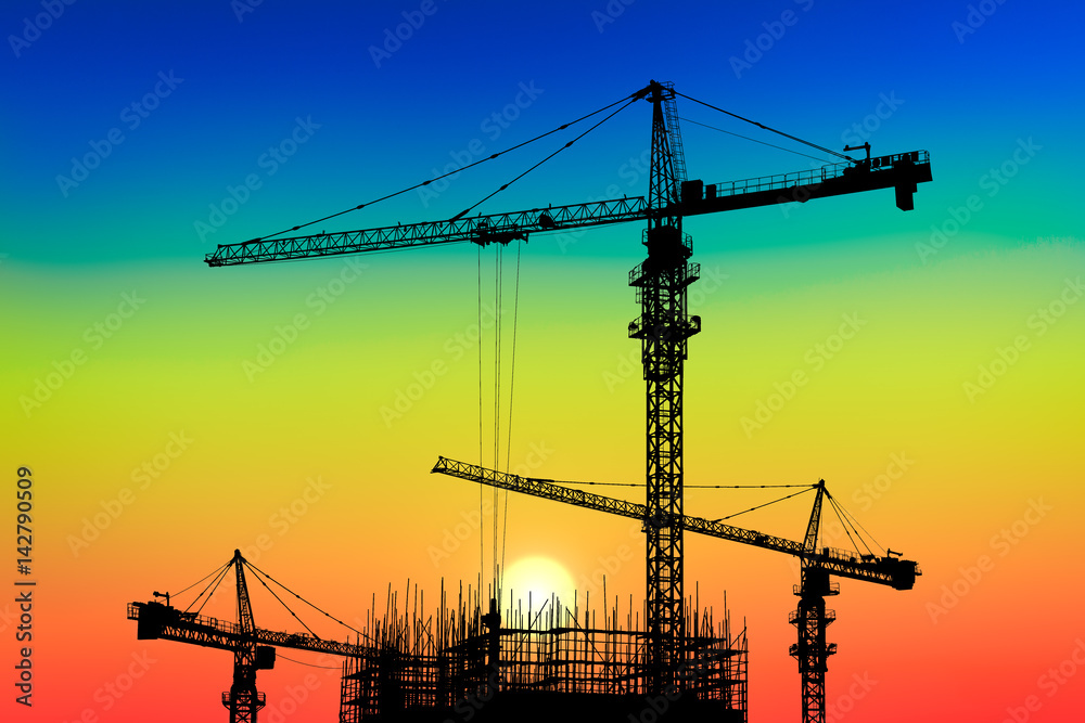 Crane and building construction site at sunset Crane and building construction site at sunset