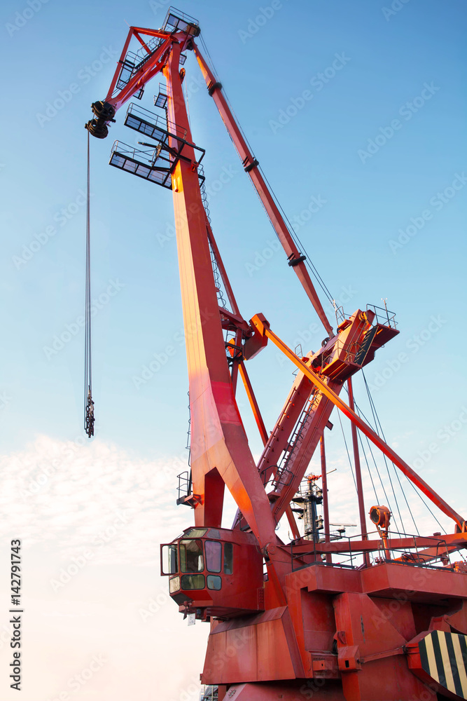 Port cargo crane over blue sky background. Sea port, crane for loading at sunset. Transportation Port cargo crane over blue sky background. Sea port, crane for loading at sunset. Transportation