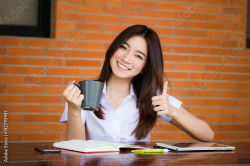 Portrait of thai adult student university uniform beautiful drinking coffee