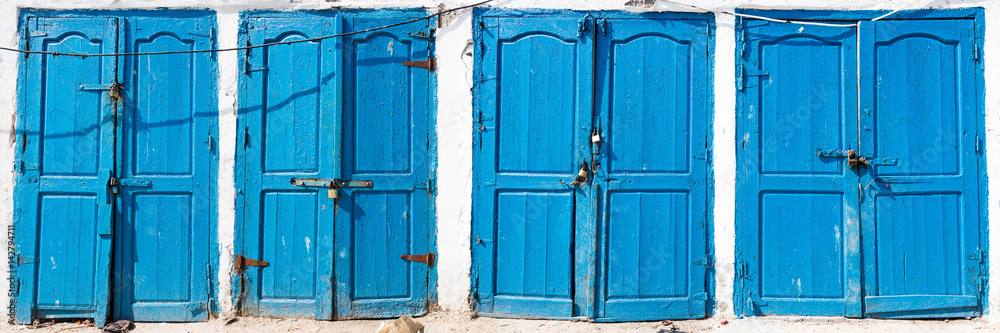 Blue rustic old door in fishing storages in Essauoira fishing port, Morocco Blue rustic old door in fishing storages in Essauoira fishing port, Morocco