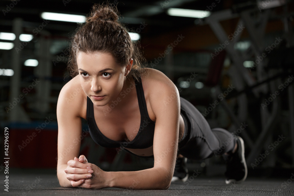 Concentrated young strong sports lady make plank Concentrated young strong sports lady make plank