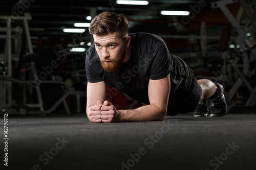 Concentrated young strong sports man make plank