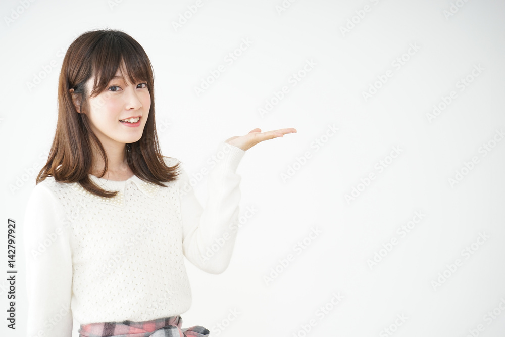 笑顔でポイントを示す若い日本人の女性 笑顔でポイントを示す若い日本人の女性